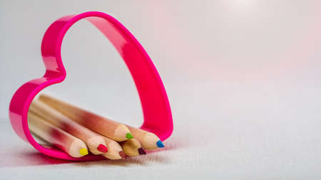 Color pencils laying in red heart symbol and represent love to creativity drawingの写真素材