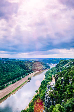 View from the Bastei to the river Elbe in Saxon Switzerland. Sun flares coming through the clouds....