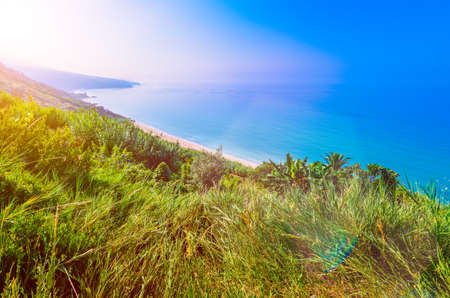 Kefalonia Island. Calm long beaches on south part of kefalonia. Morning sunflares appear over the hillの写真素材