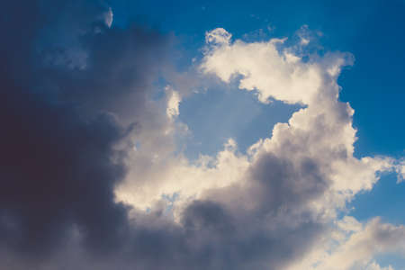 Dramatic sky with stormy clouds and sunlight.