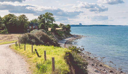 Baltic coastline. Escarpment slope lead to pebble beach. People walking along the shore hanseatic City of Luebeck - Travemuende, Germanyの写真素材