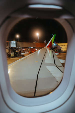 Airplane departing at evening time. Airdrome and another aircrafts are seen from aircraft window