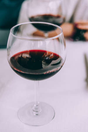 Wine glass on white table. An other glass defokused in backgroundの写真素材