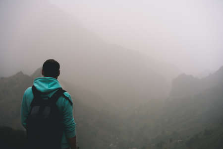 Traveler in hoodie in front of rural landscape with mountains and the ravine of Paul Valley. Santo...