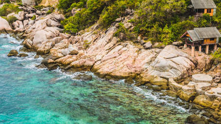 Rocky south costline of Koh Tao Islands with bungalows on granite rocks. Thailandの写真素材