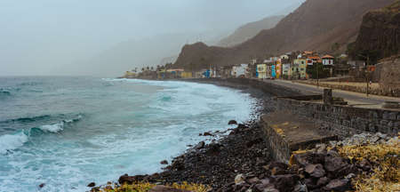 Panoramic view of rough ocean waves with blowing spray rolling onto the rocky volcanic coastline. Picturesque bay in Ribeira Grandeの写真素材