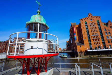 Old beacon or small lighthouse near river channel in Hamburg Hafencityの写真素材