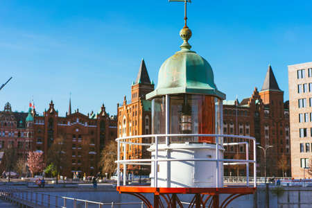Close up of old beacon lighthouse and red brick building in background, Hafencity - Speicherstadt in Hamburg, Germanyの写真素材