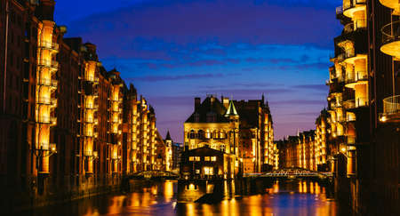 The Warehouse District - Speicherstadt in twilight. Tourism landmark of Hamburg. View of Wandrahmsfleet in light of lantern lamp. Port of Hamburg within the HafenCity quarterの写真素材