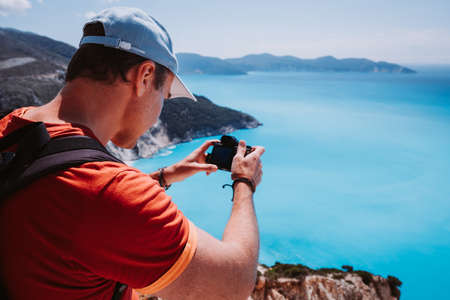 Man capture photograph of myrtos coastline sea landscape. Blue cyan water surface with island shape, Kefalonia, Greeceの写真素材