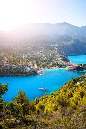 Assos village in morning light, Kefalonia. Greece. White lonely yacht in beautiful turquoise colored...