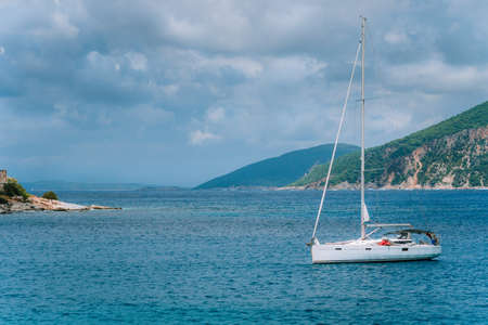 White pleasure boat approaching harbor of Fishing village Fiskardo, Kefalonia Island Greece on sunny...