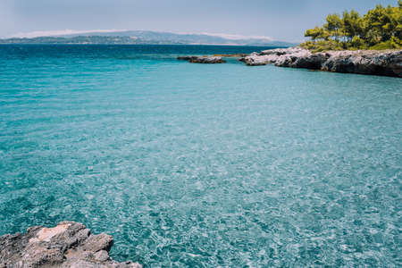 Small tranquil cove with calm blue water. Cozy pine forest along the beautiful bay. Idyllic mediterranean landscapeの写真素材