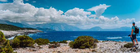 Male tourist with camera admiring breathtaking cloud scenery over the mountain range at the...