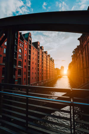 The red brick warehouse - Speicherstadt district in Hamburg Germany, framed by steel bridge arch...