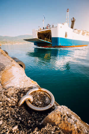 Big ferry boat with passengers and cars arrives beautiful Greek island. Summer vacationの写真素材