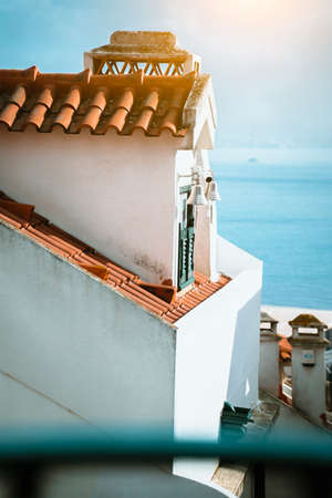 Typical lisbon roof with red tiles and a window with traditional colorful shutters. Streets and architecture of Lisbon, Lisboaの写真素材