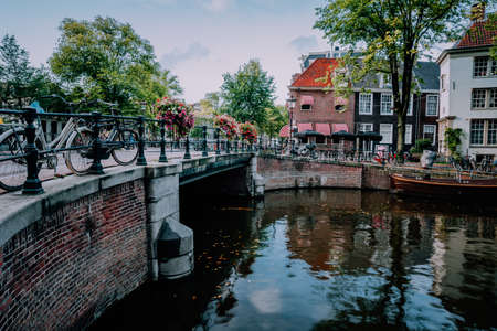 Autumnal Amsterdam canal scene with bicycles and bridgeの写真素材