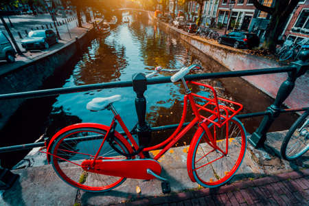 Symbols of Amsterdam: Red Bicycle parked on a bridge, Netherlands. Travel, romance, vacation, culture conceptの写真素材