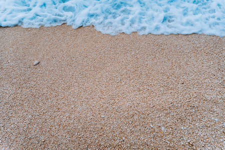 Shape of rolling soft foam wave of blue turquoise sea water on pebble stone beach. Background. Top viewの写真素材