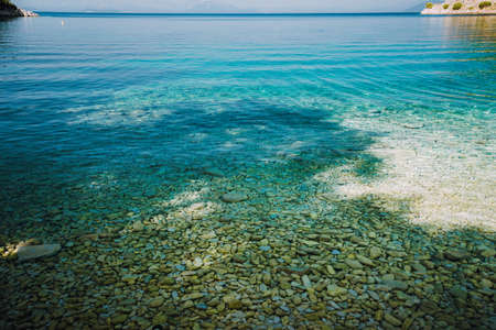 Stones seen through the crystal clear waters of mediterranean sea. Calm turquoise waterの写真素材