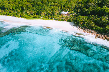 Aerial photo of bizarre paradise tropical beach Anse Bazarca at Mahe island, Seychelles. White sand, turquoise water, palm trees, granite rocksの写真素材