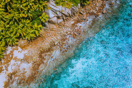 Aerial drone helicopter view of crystal clear turquoise water and amazing granite rocks. La Digue...