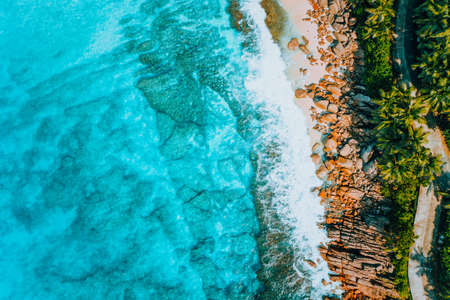 Aerial bird eye shot of tropical coastline with tropical rocky beach and palm trees at Seychelles. Summer vacation, travel and lifestyle conceptの写真素材