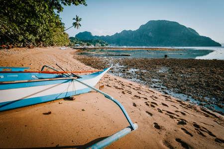 View of El Nido bay with local banca boat in front at low tide, picturesque scenery in the afternoon, Palawan, Philippinesの写真素材
