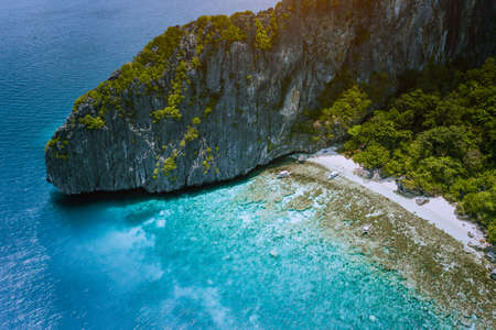 Aerial drone view of tropical beach with banca boats on Entalula Island. Karst limestone rocky...