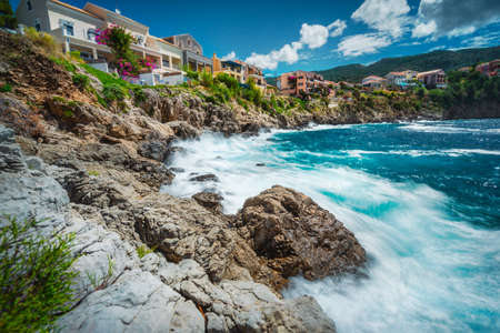 Long exposure of picturesque mediterranean Assos village, Kefalonia island Greece. Colorful houses at the rocky shore. Summer vacation travelの写真素材