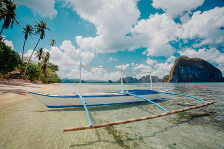 Seaview with traditional fishing boat on the beach under cloudy sky in El Nido. Palawan, Philippinesの写真素材