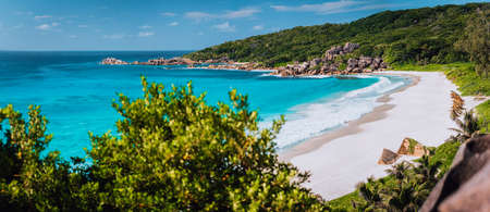Panorama of epic Grand Anse Beach in La Digue island, Seychelles. White sand beach, big ocean waves and unique granite rocks along coastline. Summer vacation and holiday travel conceptの写真素材