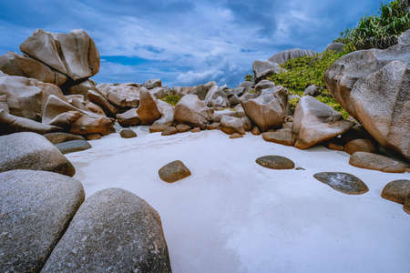 Tropical small secret pristine white sand beach surrounded by granite boulders. Anse Marron beach,...