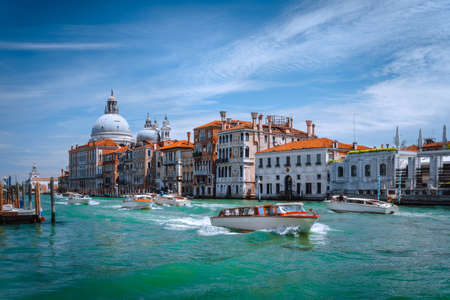 Pleasure tourist boats on Grand Canal and Basilica Santa Maria della Salute, Venice, Italyの写真素材