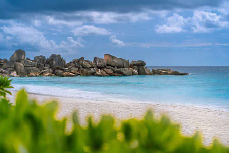 Grand Anse beach at La Digue island in Seychelles. White sandy beach with blue ocean lagoon. Green...