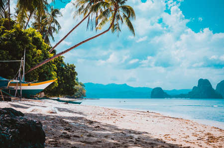 Banca boat on shore under palm trees.Tropical island scenic landscape. El-Nido, Palawanの写真素材