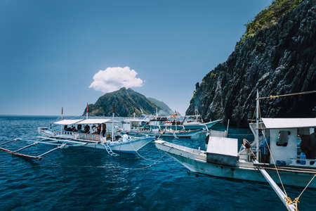 Tourist banca boats on blue sea water surface on island hopping tour. El Nido, Palawan, Philippinesの写真素材
