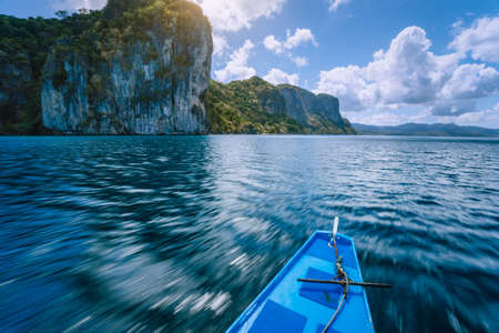 Island hopping Tour boat on speed passing exotic karst limestone islands on travel tour trip exploring Bacuit archipelago, El Nido, Philippines.の写真素材
