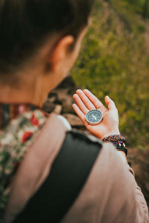 Women check direction at the compass in her hand to find right hiking pathの写真素材
