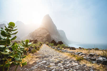 Santo Antao Island, Cape Verde. Epic Mountain peak on stony hiking path to Ponta do Sol over arid Aranhas valley with old abandoned house ruinsの写真素材