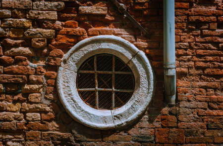 Venice Italy. Old circular vintage window in an old brick wall.