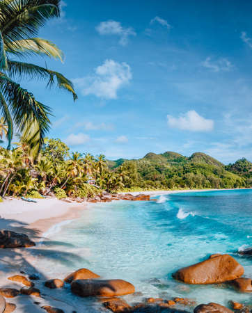 Mahe, Seychelles. Beautiful Anse intendance beach. Calm ocean waves rolling towards the shore with coconut palm trees.の写真素材