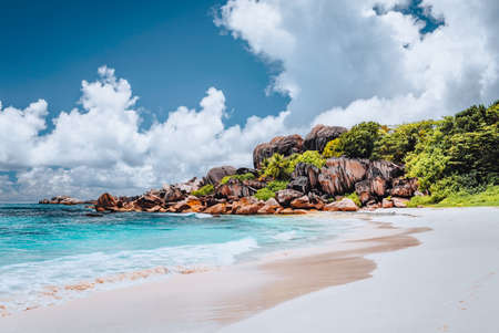 Grand Anse tropical beach in La Digue, Seychelles. Famous granite rock formations and white clouds aboveの写真素材