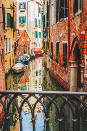 Venice, Italy. Narrow channel street and colored houses with local boats in Veneziaの写真素材