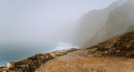Santo Antao, Cape Verde - Sandy trail hike path from Cruzinha da Garca to Ponta do Sol. Moody Atlantic coastline with ocean wavesの写真素材
