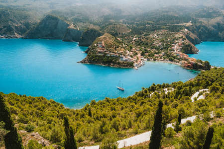 Top view to Assos village. Landmark place of Kefalonia island. Lonely white yacht at anchor in calm...
