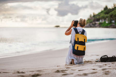 Travel tourist female photograph sunset at tropical beach. Recreation hobby summer vacation lifestyle conceptの写真素材