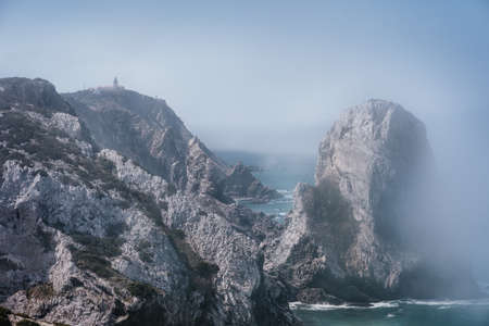 Rocky coastline of Praia Da Ursaa in morning fog, Sintra, Portugal. Giant sea stacks towering up along atlantic ocean coast. Holiday travel vacation season.の写真素材