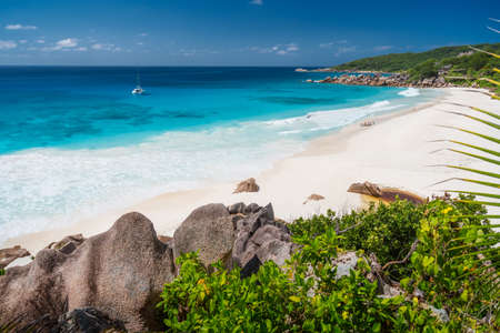 Petite Anse, La Digue in Seychelles - Tropical and paradise beach. Yacht boat at anchor in blue lagoonの写真素材